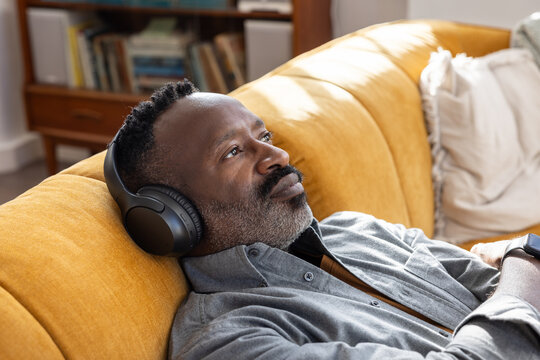 Man Deep in Thought on Couch with Headphones