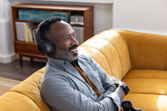 Man Relaxing on Couch with Headphones and Smile