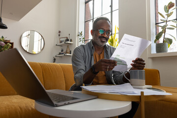 Happy man reviewing his account summary at home