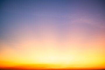 Sunset or sunrise sky with a vibrant gradient of orange, gold, and soft blue. Clear atmosphere with wispy clouds. Peaceful, natural light background. hope, freedom, new day and inspirational Concepts