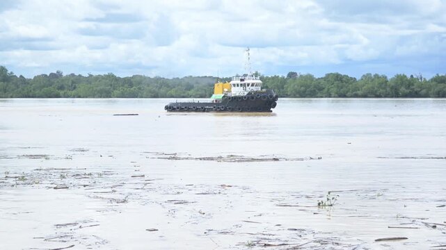 Tideng Pale - Indonesia, 22 November 2025 : tugboats towed pontoons loaded with coal across the river