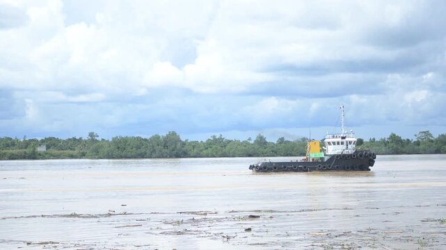 Tideng Pale - Indonesia, 22 November 2025 : tugboats towed pontoons loaded with coal across the river