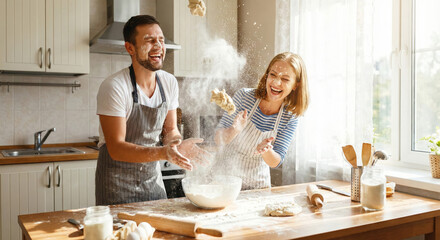 A couple is having fun in the kitchen while baking Flour is flying everywhere