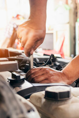 Vertical Mechanic man hands repairing car shop. Man hands fixing Car machinery vehicle mechanical service. Vertical horizon vehicle hood checking automobile. Car motor Workshop oil garage maintenance