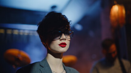 Elegant woman taking microphone in scene light closeup. Chic lady in glasses 