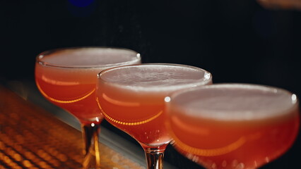 Barman hands splashing cocktails with lemon juice closeup. Bartender preparing