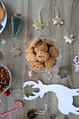 Various Christmas decorations, cookies, chocolate and nuts on wooden background. Flat lay.