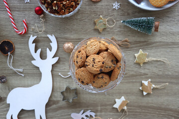 Various Christmas decorations, cookies, chocolate and nuts on wooden background. Flat lay.