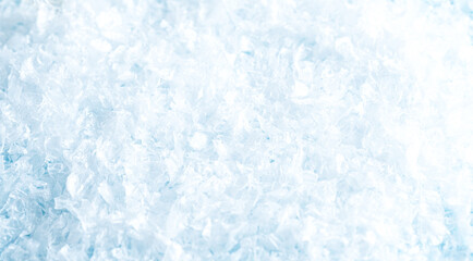 Bright pale blue surface completely covered with softly blurred crushed ice crystals, creating a cold winter background with gentle texture and copy space
