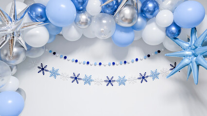 Festive winter backdrop with blue, white and silver balloons and central copy space.
