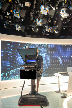 Modern broadcasting studio featuring sophisticated lighting systems, a professional camera rig, and a digital backdrop