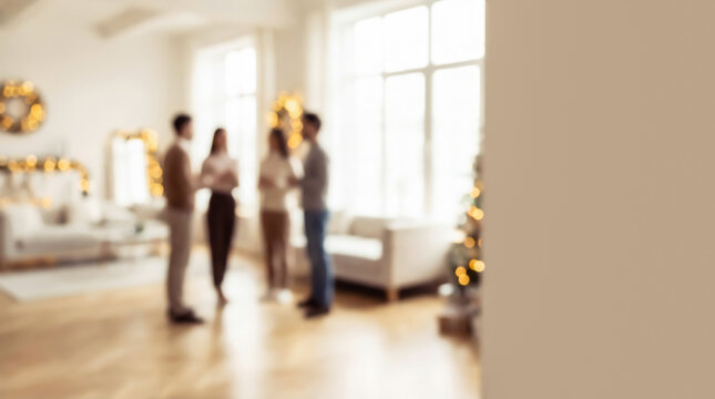 Blurred photo of a group of friends standing in a living room with New Year decor and large windows