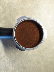 Fresh Ground Coffee in Portafilter on Wooden Surface