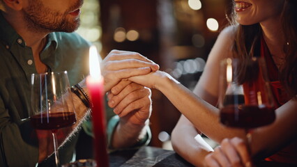 Cheerful pair enjoy conversation in intimate cafe at romantic date closeup.