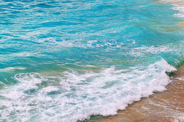 Vibrant ocean waves crashing on sandy beach shoreline
