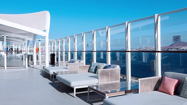 Open deck with cushioned seating glass railing bright sky clean surfaces minimal design and calm spacious atmosphere.
