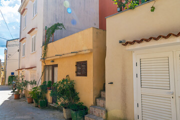 Obraz premium Charming mediterranean street with colorful houses and lush greenery. Omišalj, Krk island, Croatia