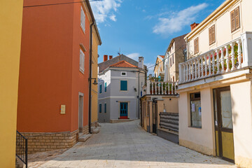 Charming mediterranean village street with colorful architecture under blue sky. Omišalj, Krk island, Croatia