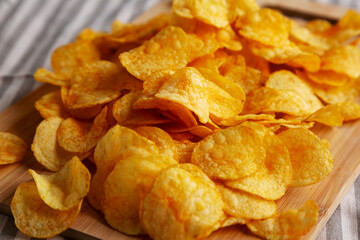 Crunchy Meat Frying Pan with Mushrooms Chips on a Wooden Board, side view.