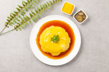 밥을 고기나 야채 따위와 함께 볶고 그 위에 달걀을 얇게 부쳐서 씌운 요리.
A dish made by stir-frying rice with meat or vegetables and topping it with a thin layer of fried egg.

