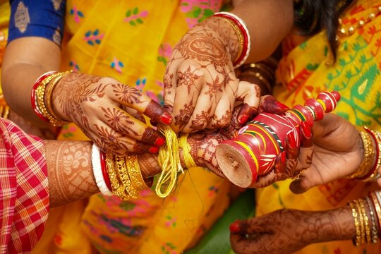 Bengali Hindu Wedding Ritual of Tying Sacred Yellow Thread and gachkouto on Bride&rsquo;s Hand