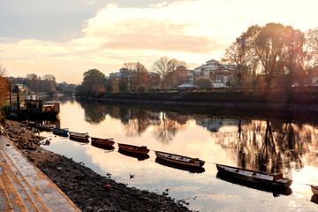 Beautiful view of rowboats moored in line on the River Thames on a cold day in late autumn, early winter in Richmond, Central London, England, UK