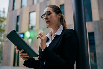 Fototapeta premium Side view of businesswoman walking with digital tablet, expressing confident progress, mobile task flow and calm control in professional tech routine