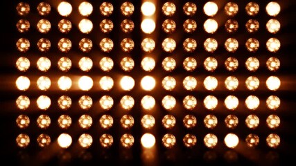 Rows of Warm Circular Stage Lights Creating a Bright Center Spotlight Effect Across a Dark Background