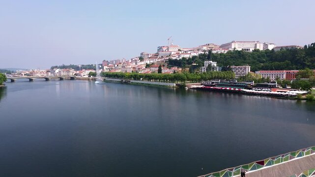 Aerial backward flight revealing Coimbra and the University of Coimbra over the Mondego River