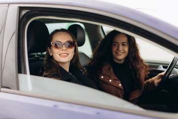 Happy young women enjoying car road trip together