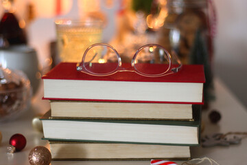 Cookie jar, tea, wine, nuts, books, lit candles and Christmas decorations on the table. Cozy Christmas hygge at home. Selective focus.