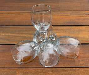 four wine glasses lie on a wooden table