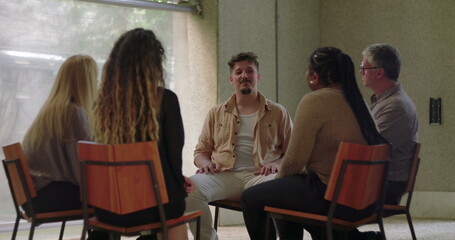 Obraz premium Man opening up to group therapy circle, expressing vulnerability with emotion as peers listen with empathy and support in healing setting