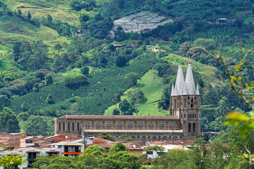 Beautiful Basilica of the Immaculate Conception with in the background  a hill with coffee and bananas fields  in Jard&iacute;n, Colombia.