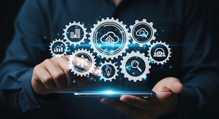 Man using a smartphone with holographic gears displaying cloud computing and data analytics concepts for business and technology solutions in the digital age