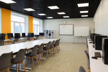 Modern classroom equipped with computers and ample workspace for student collaboration
