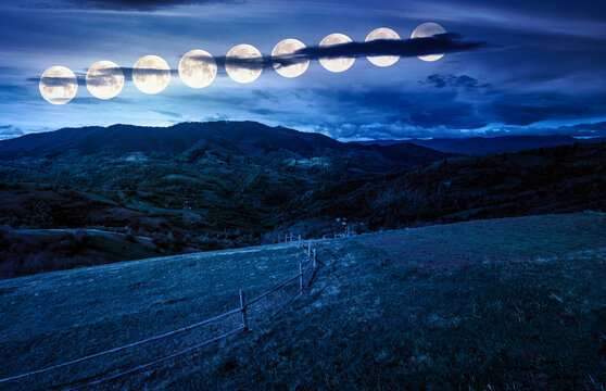 wooden fence on hillside with rural field in mountains at night. beautiful countryside landscape with rolling hills and pasture in spring in full moon light. fake news or conspiracy concepts