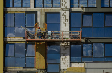 Construction cranes and new buildings, construction work of modern skyscrapers on a sunny day.