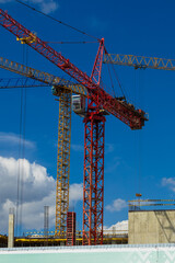 Construction cranes and new buildings, construction work of modern skyscrapers on a sunny day.