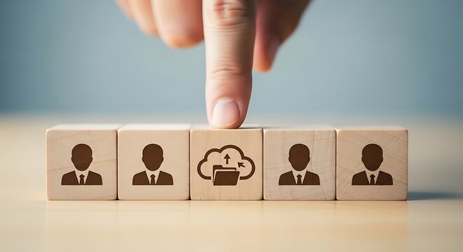Human resources and cloud computing concept finger pointing at wooden blocks with people icons representing team and technology integration