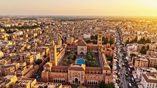 Aerial view of ben youssef madrasa and the bustling souk market in the old city of marrakech at sunset, morocco 4k video