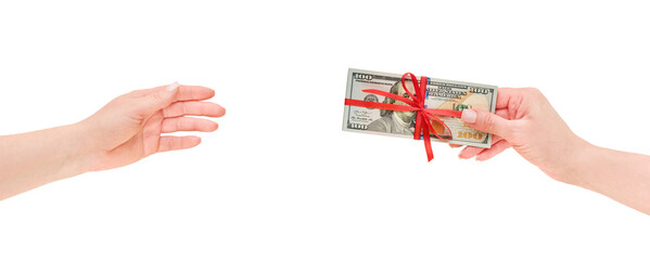 Female hand gives to another female US dollar money cash with red ribbon and bow isolated in white background with clipping path. Design element. US Dollars money as a gift, win or bonus concept.
