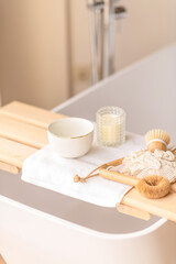 Minimal spa setup on a bath tray with natural accessories