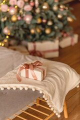 Gift box with pink ribbon in a warm festive setting