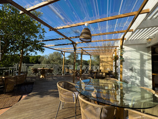 Stylish outdoor seating area connected to a modern living space with glass sliding doors.