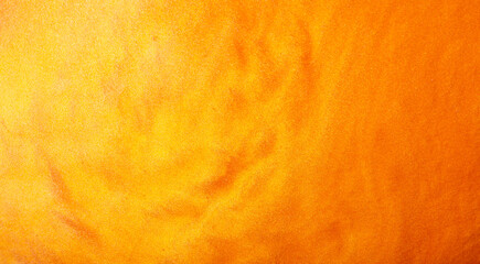 Shimmering gold abstract background. Liquid gold texture waves and swirls. Beautiful shiny yellow texture with glitter. Liquid gold metallic paint close-up.