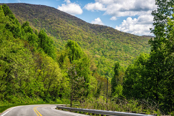 Rural empty mountain road in Lyndhurst, Virginia summer countryside season with lush trees forest woods and mountain ridge