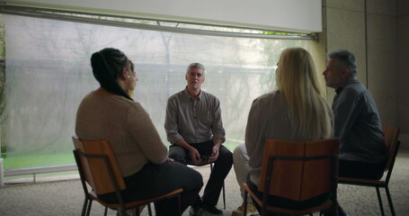 Middle aged man delivering heartfelt confession in therapy circle, emotional breakthrough shared...
