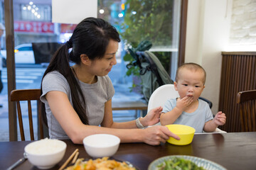 Mother feeding her baby at restaurant during meal time