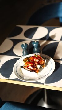A plate of food with two tacos on it sits on a table. The table is decorated with a blue and white pattern